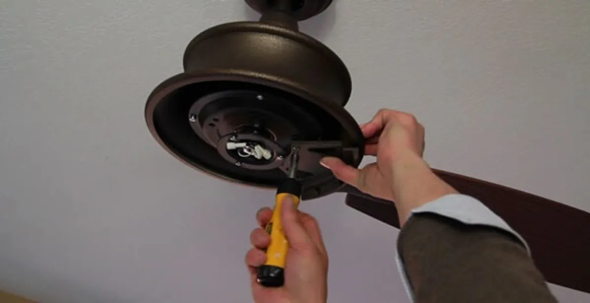 Electrician installing ceiling fan mounting bracket and fixture in Chico, CA