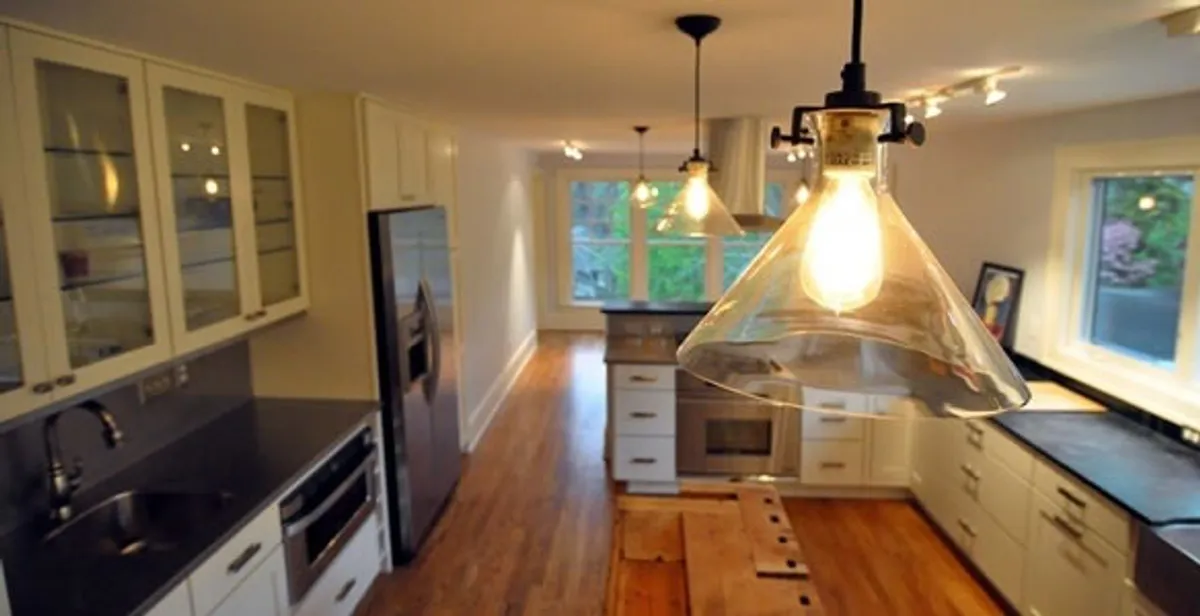 Residential electrician installing modern indoor light fixture in a home in Chico, CA
